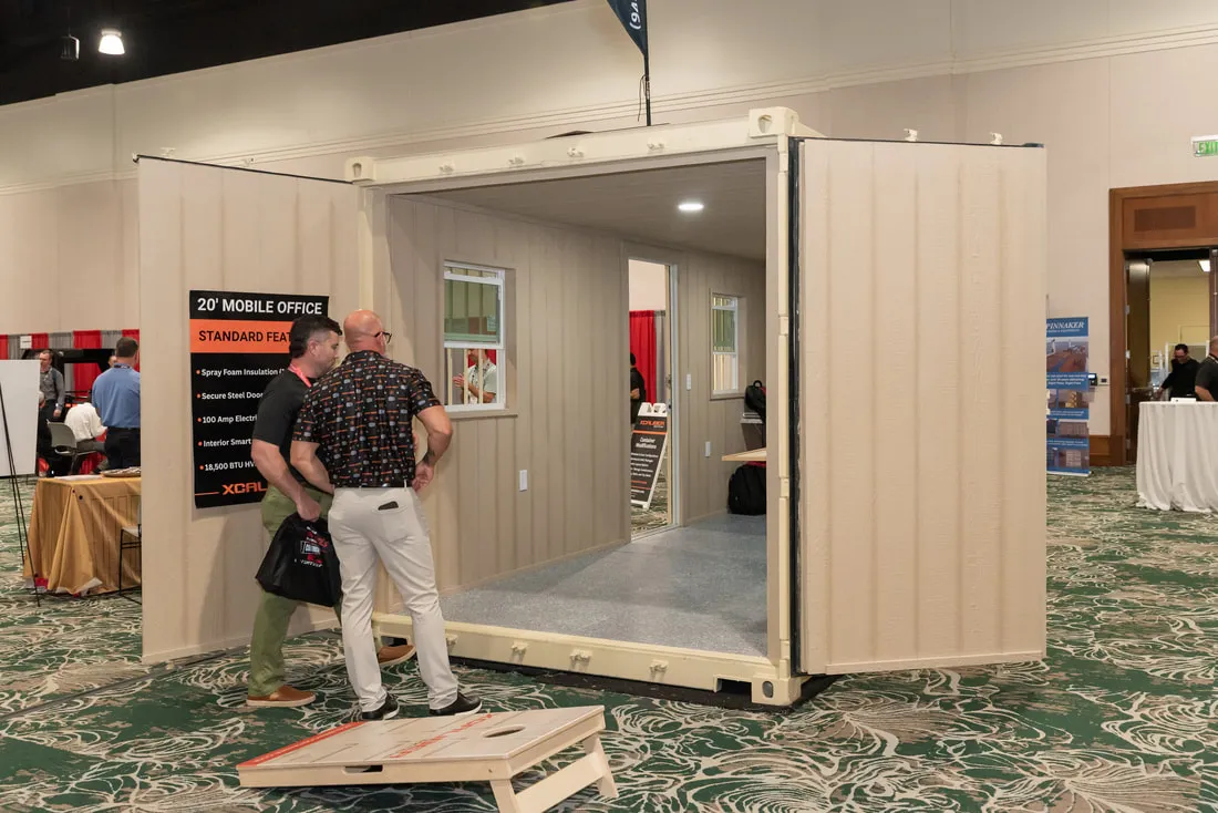 Visitors at a container office booth at the 2026 NPSA trade show